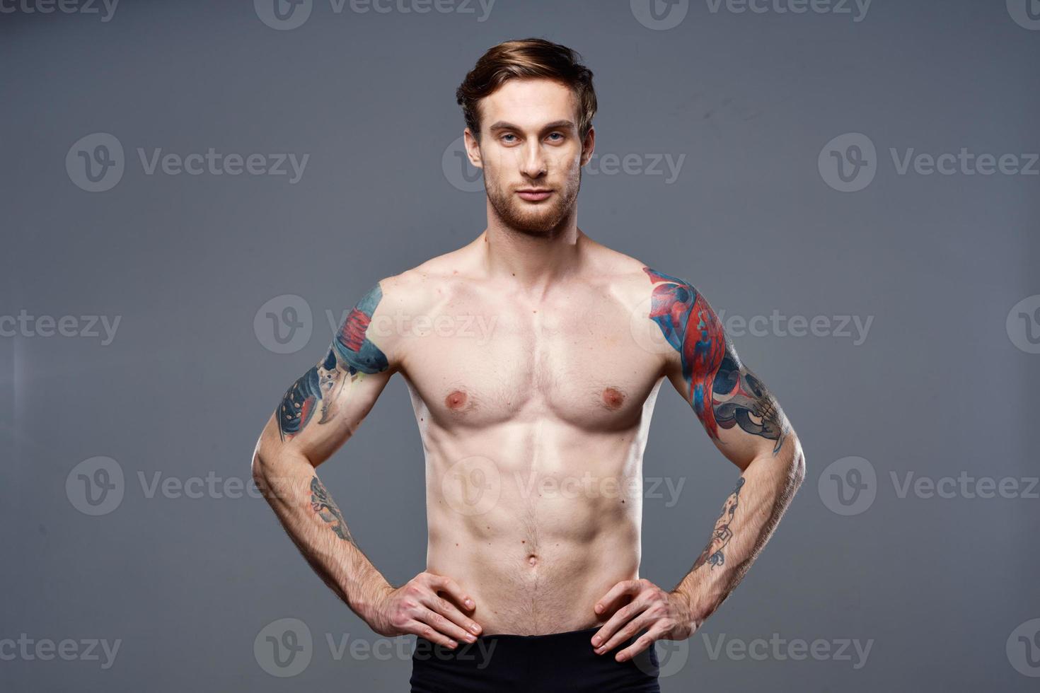 atletisk man med pumpade upp magmuskler tatueringar på hans vapen foto