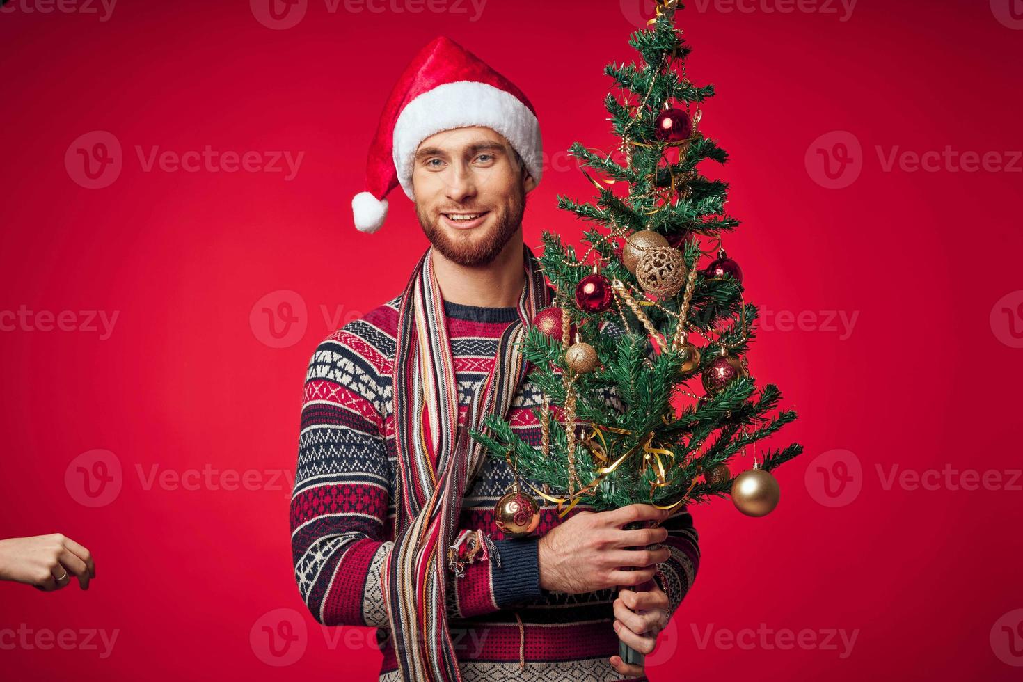 man med dekorerad jul träd Semester jul roligt röd bakgrund foto