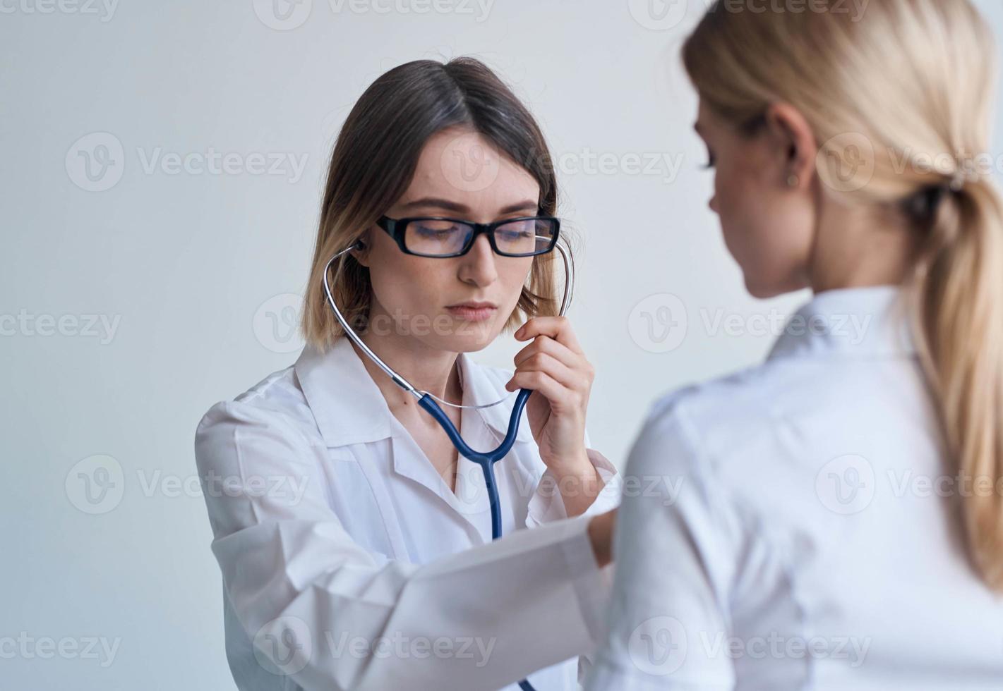 professionell läkare kvinna med stetoskop och hjärtslag hälsa patient ljus bakgrund foto