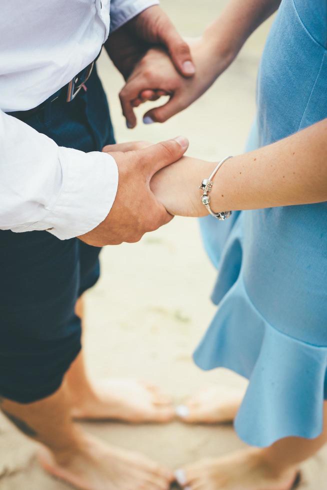 par som håller händerna på en strand foto