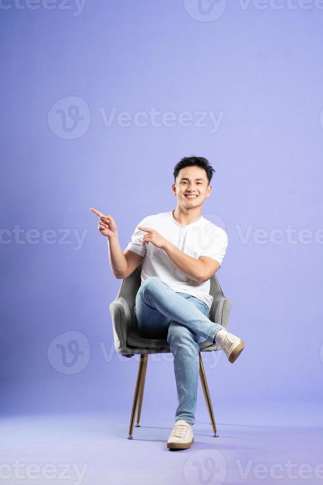 bild av asiatisk pojke Framställ på lila bakgrund foto