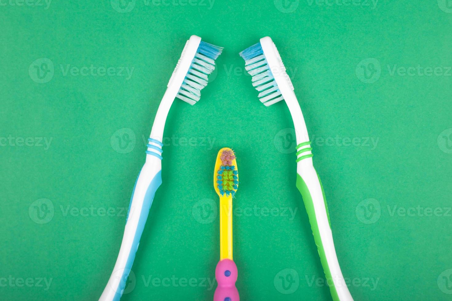 uppsättning tandborstar för hela familjen på grön bakgrund foto
