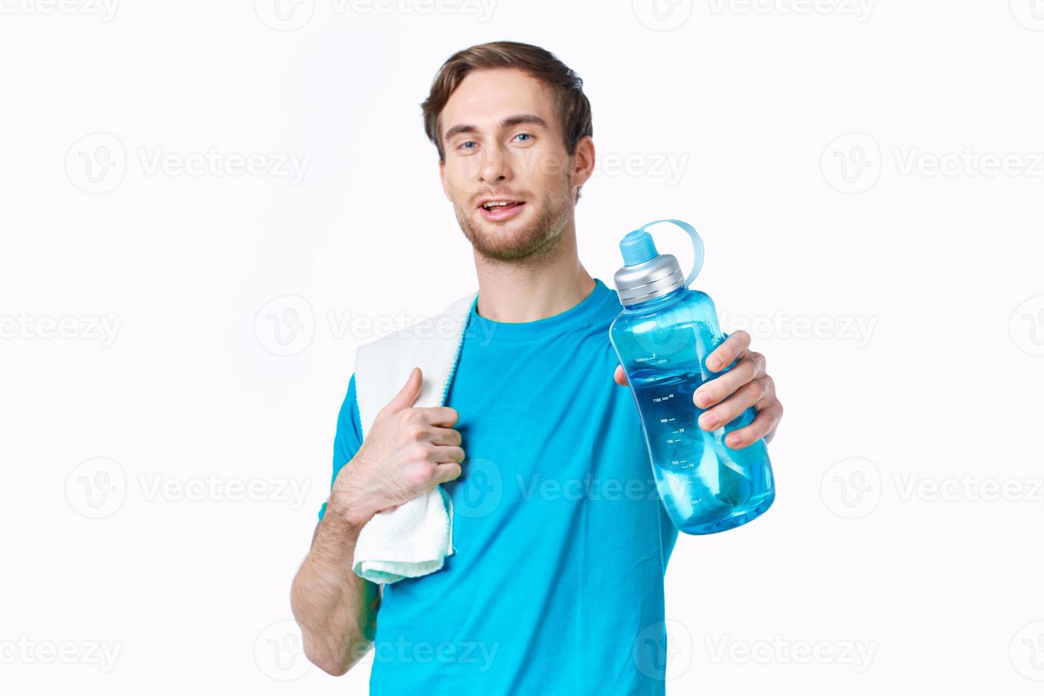 sportig man i blå t-shirt vatten flaska handdukar träna foto