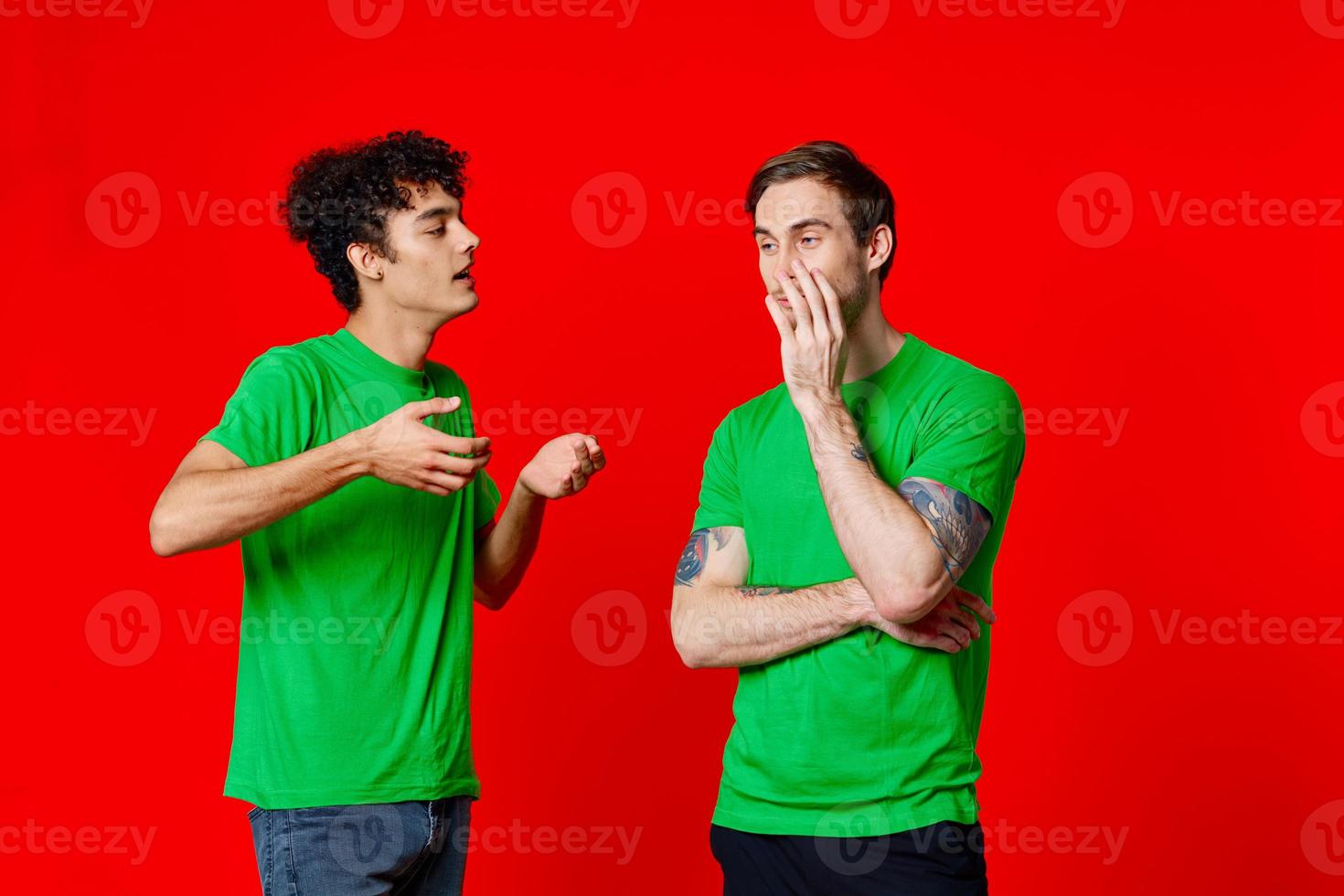 glad vänner grön t-shirt kommunikation känslor röd bakgrund foto