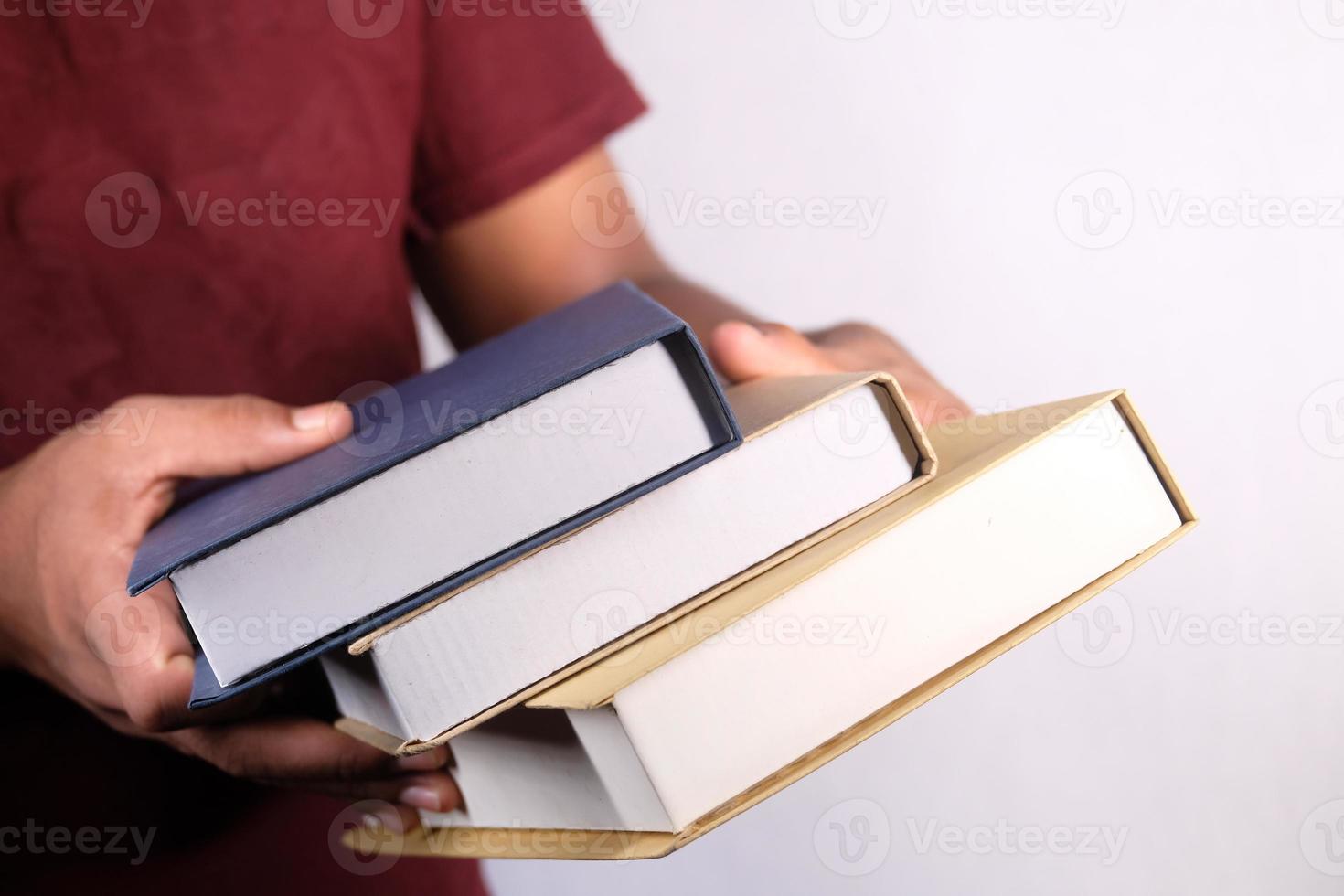 händer som håller bunten med böcker på vit bakgrund foto