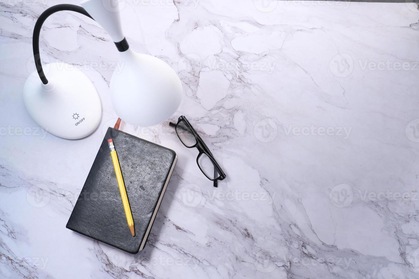 ovanifrån av en lampa, dagbok och penna på marmorbakgrund foto