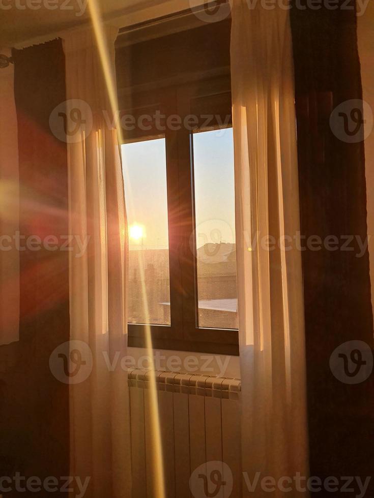 bakgrund en fönster med gardiner genom som de stigande Sol kommer i foto