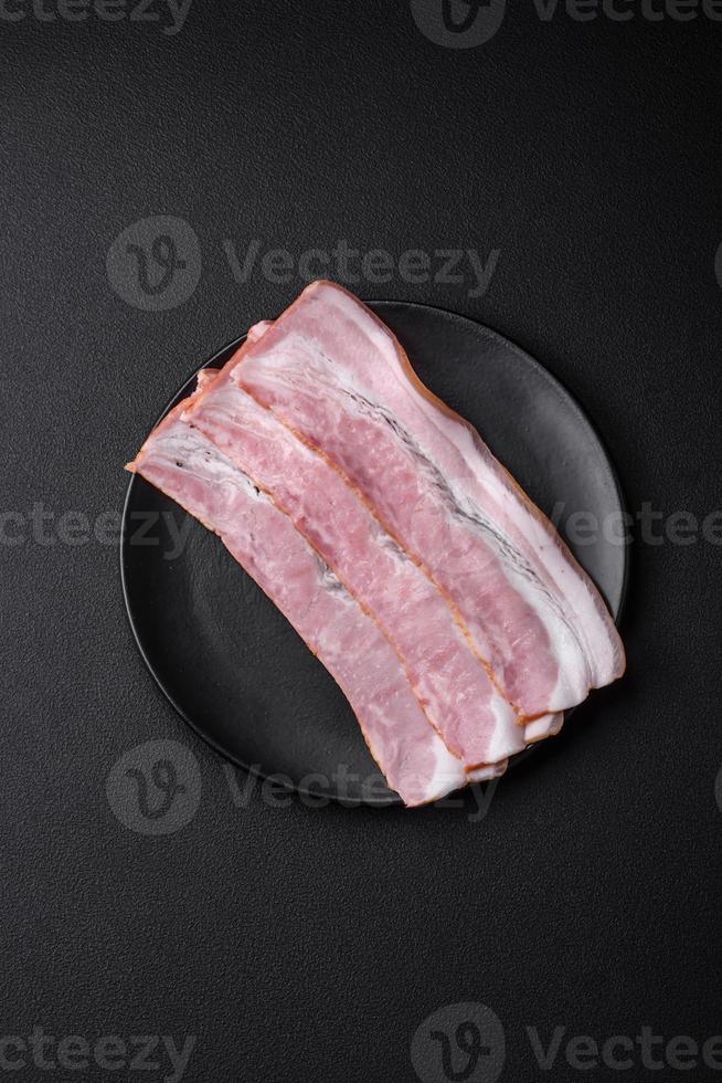utsökt färsk bacon Ränder med kryddor och salt foto