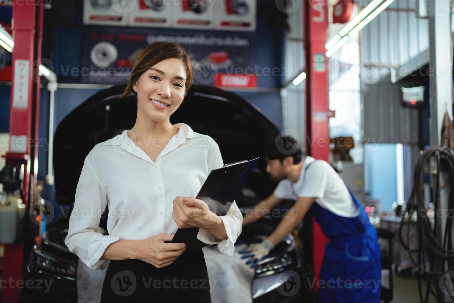 porträtt asiatisk kvinna klienter kontroll vård tjänster och reparera bilar i bil reparera garage foto
