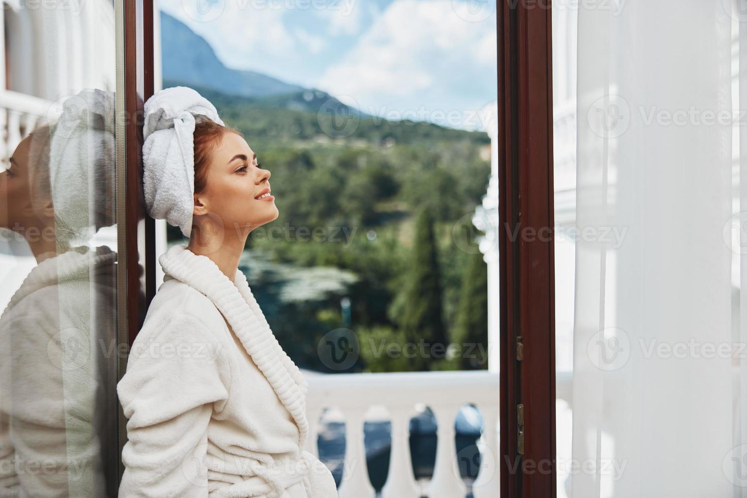 porträtt kvinna stående på de balkong ser på de bergen semester i de bergen i sommar oförändrad foto