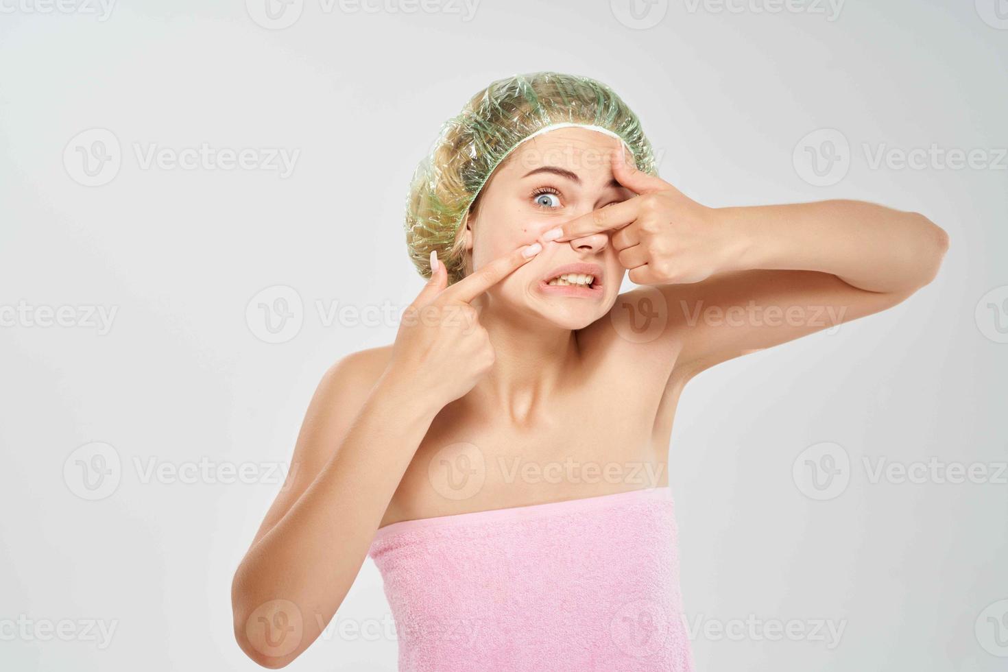 kvinna pressar finnar på henne panna badrum foto