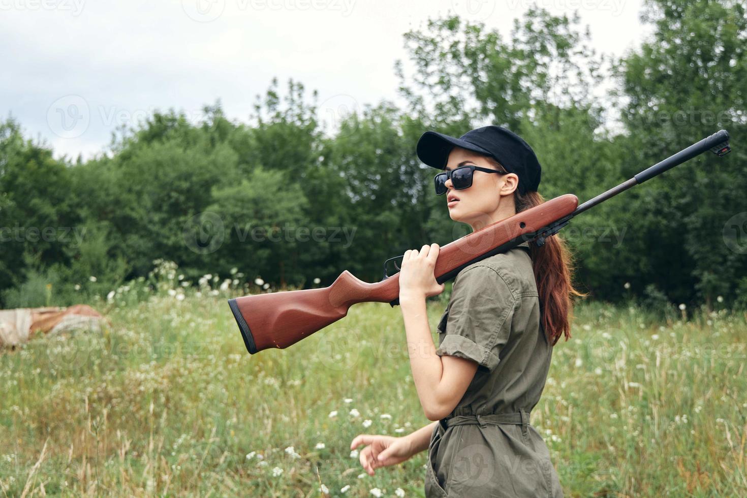 kvinna på natur resa solglasögon vapen grön overall foto