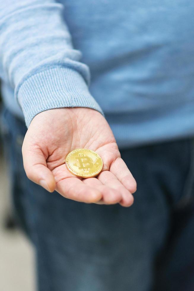 man som håller bitcoin i handen foto