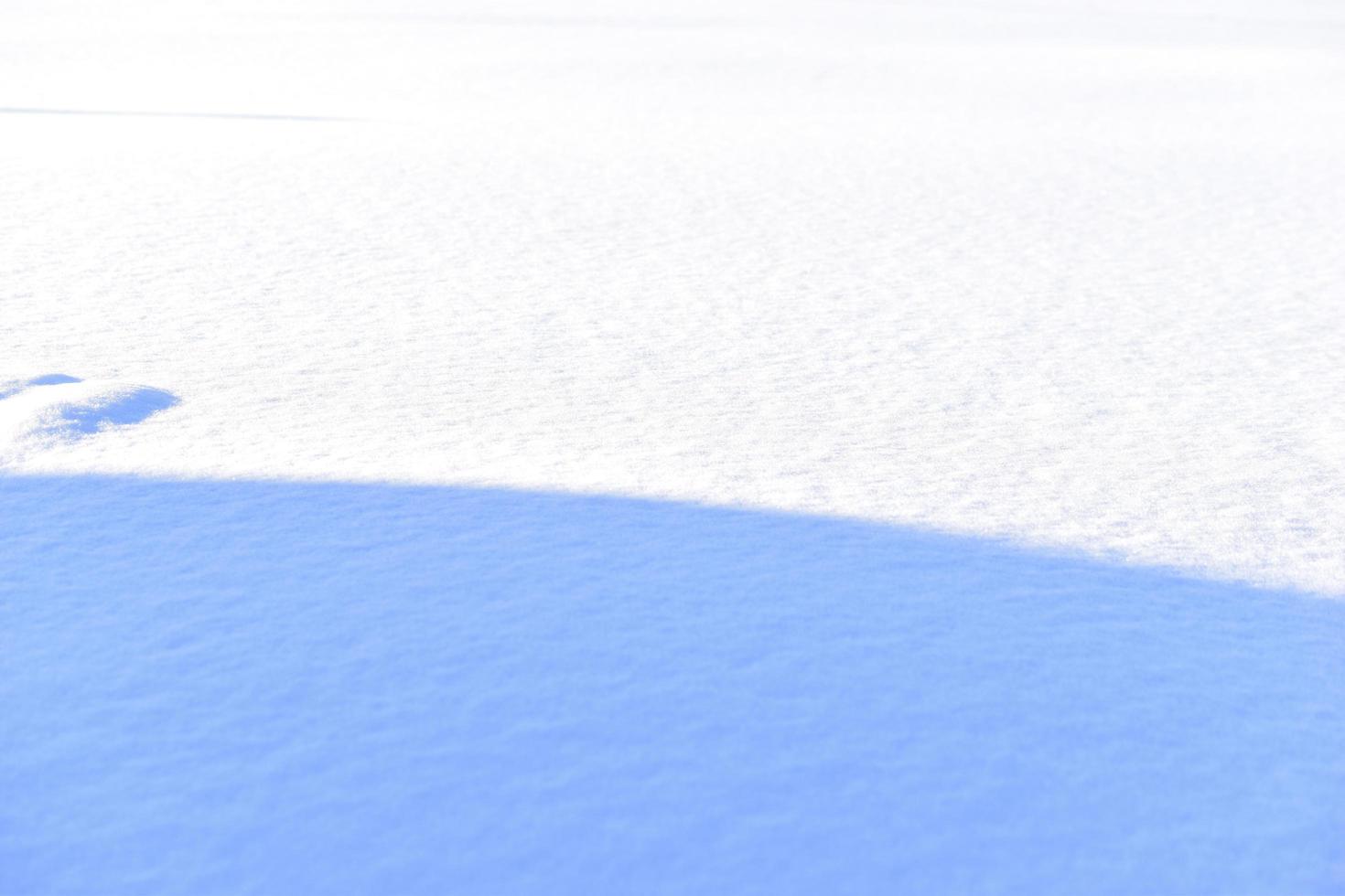 snöig yta på vintern med skuggor på kvällen foto