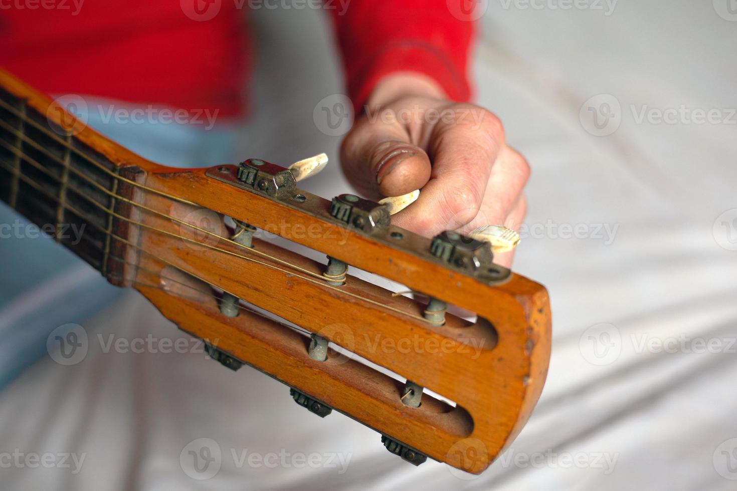 musikerhand vrider gitarrens melodier och justerar instrumentet foto