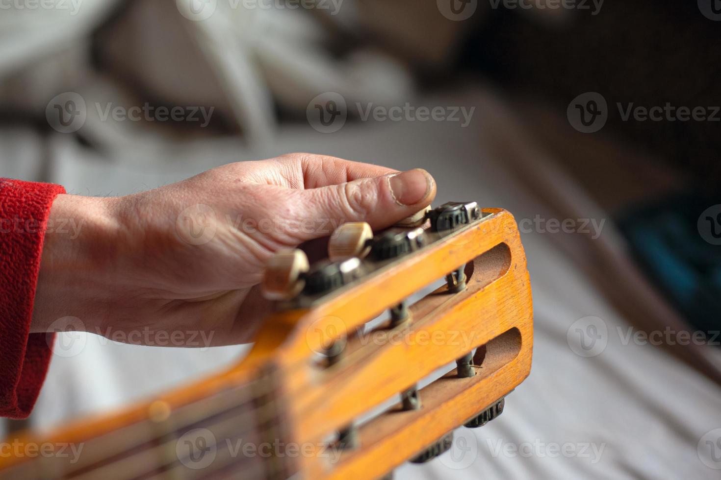 musikerhand vrider gitarrens melodier och justerar instrumentet foto