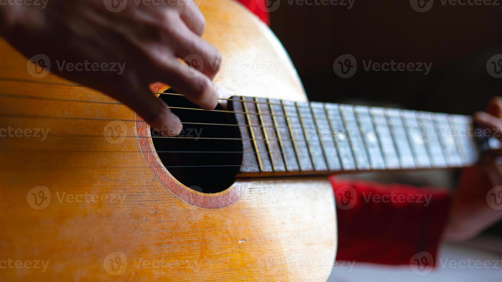 spelar en akustisk gitarr med nylonsträngar foto