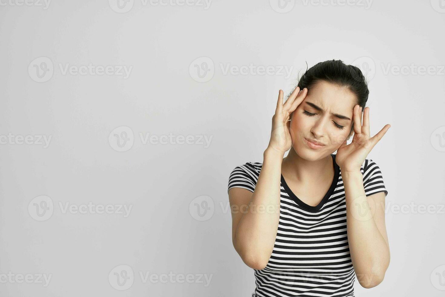 sjuk kvinna i en randig t-shirt smärta i de nacke ljus bakgrund foto