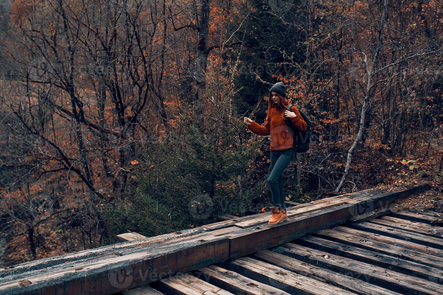 kvinna turist går över de bro över de flod resa i höst foto