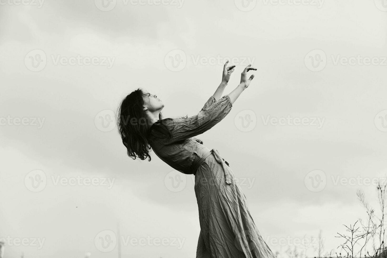 skön kvinna i klänning gestikulerar med händer Framställ elegant stil foto