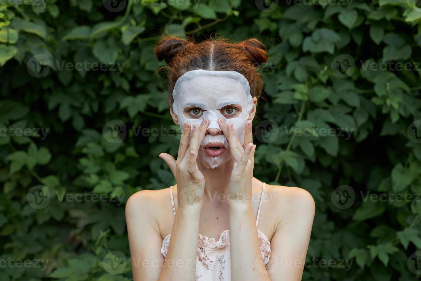 skön kvinna anti rynkor mask Rör din ansikte med din händer dermatologi buskar i de bakgrund foto