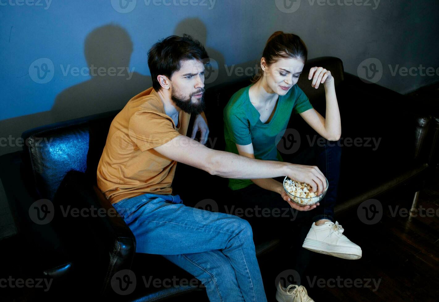 en man och en kvinna är tittar på en film i de bio på de soffa inomhus foto