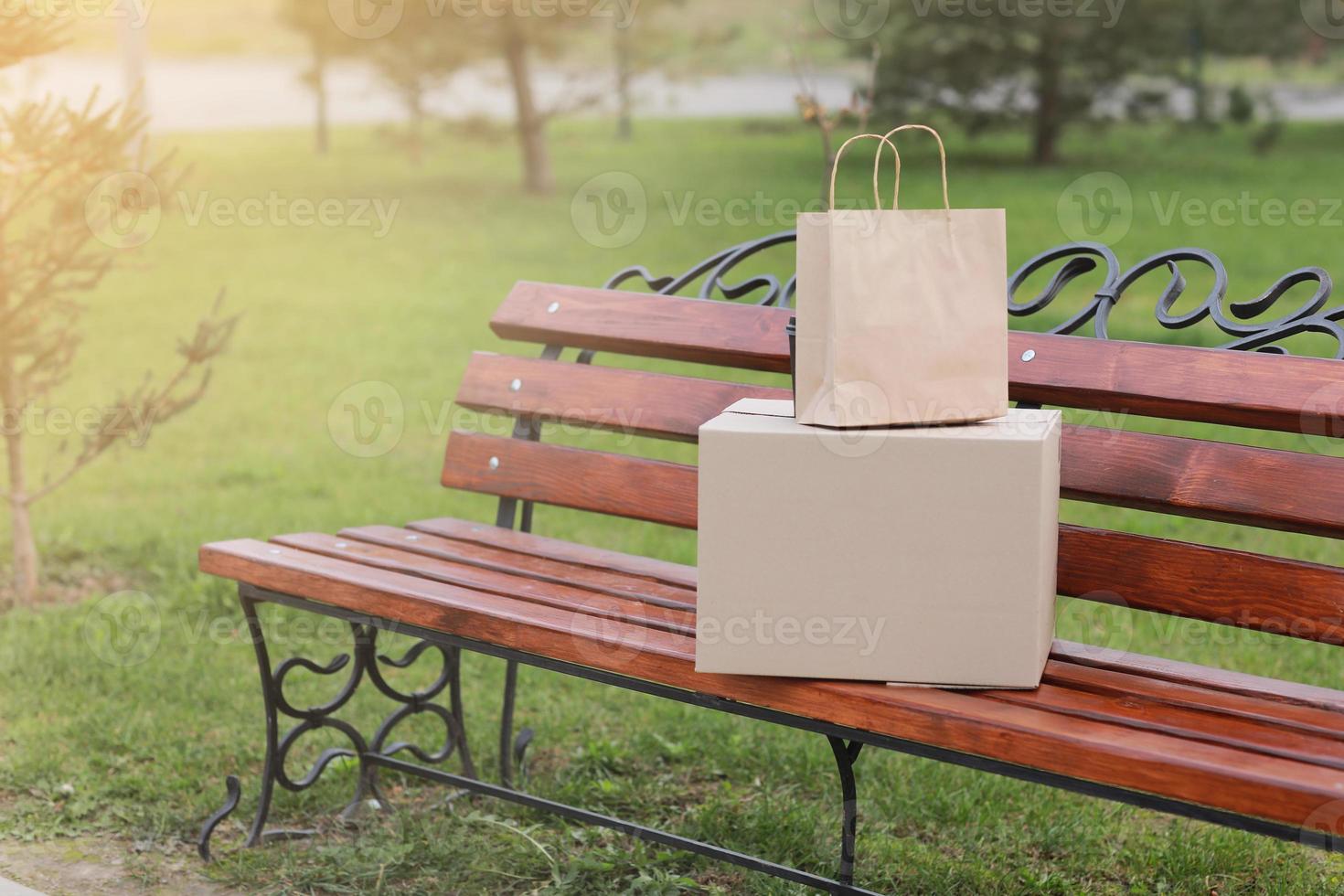 två paket på en bänk utomhus. take-out koncept foto