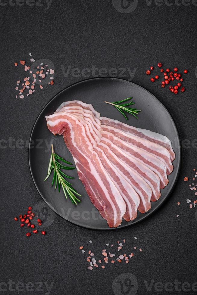 utsökt färsk pancetta med salt och kryddor skära in i tunn skivor foto