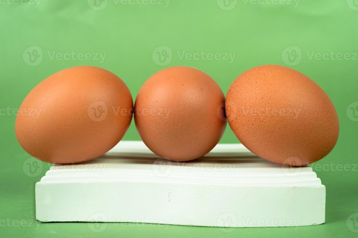 kyckling ägg på en vit underlägg på en grön bakgrund. foto