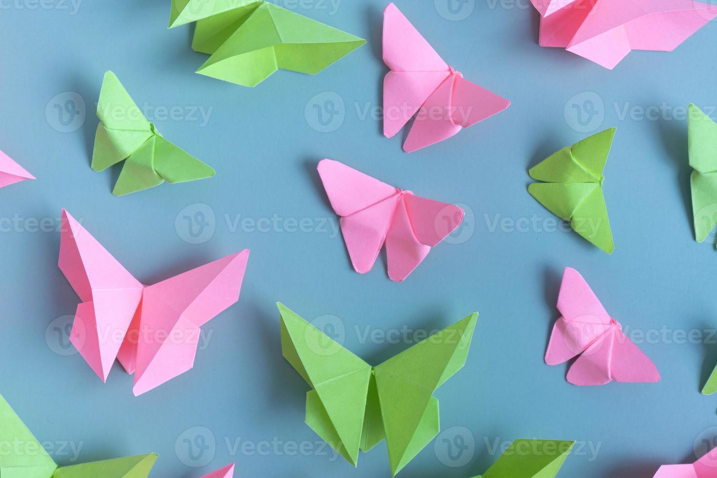 papper fjärilar grön och rosa Färg platt lägga på en färgad bakgrund. lätthet, vår skönhet begrepp foto