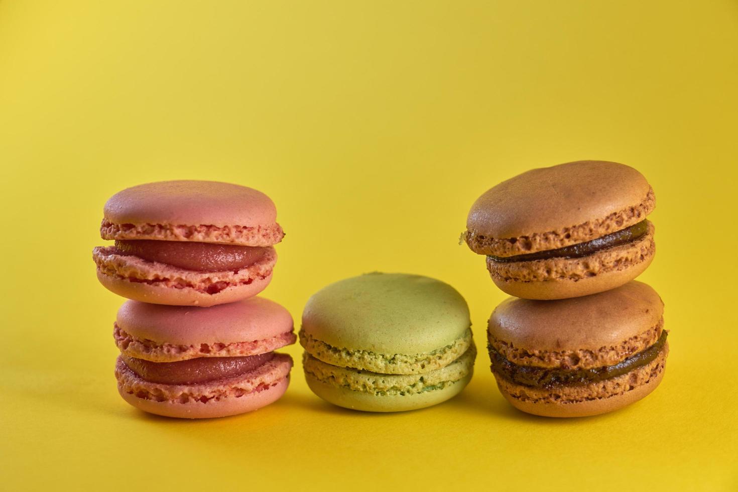 tårta macaron närbild på en gul bakgrund, smak mandelkakor pastellfärger och utrymme för text. foto