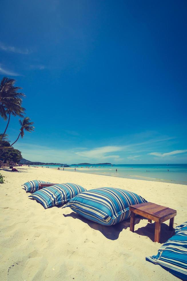 vacker tropisk strand och hav med stol på blå himmel foto