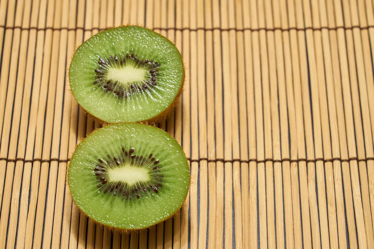 mogen grön skär kiwi på en halmbakgrund med plats för text. foto