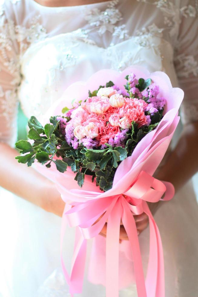 brud innehav en skön bukett blommor foto