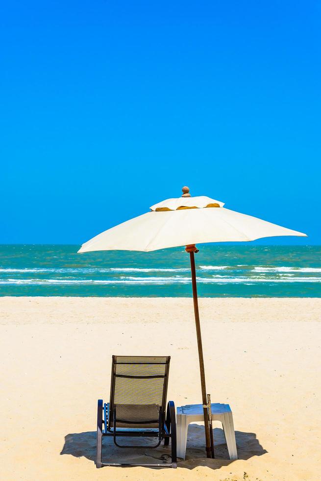 paraply och stol på stranden foto