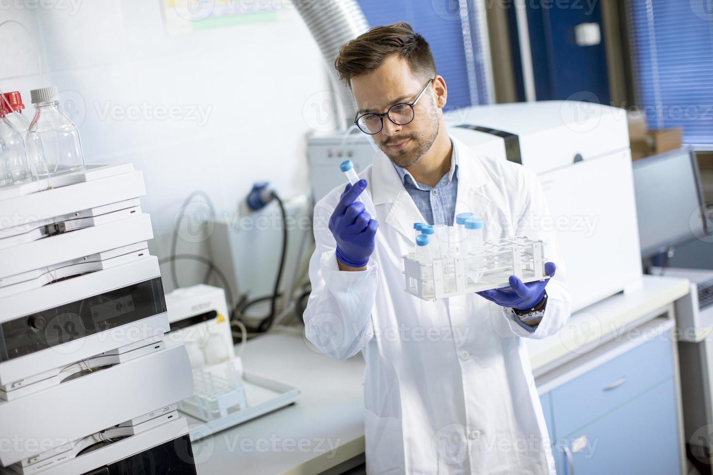 ung forskare som arbetar med kemiska prover i laboratorium med hplc-system och kromatografiutrustning foto