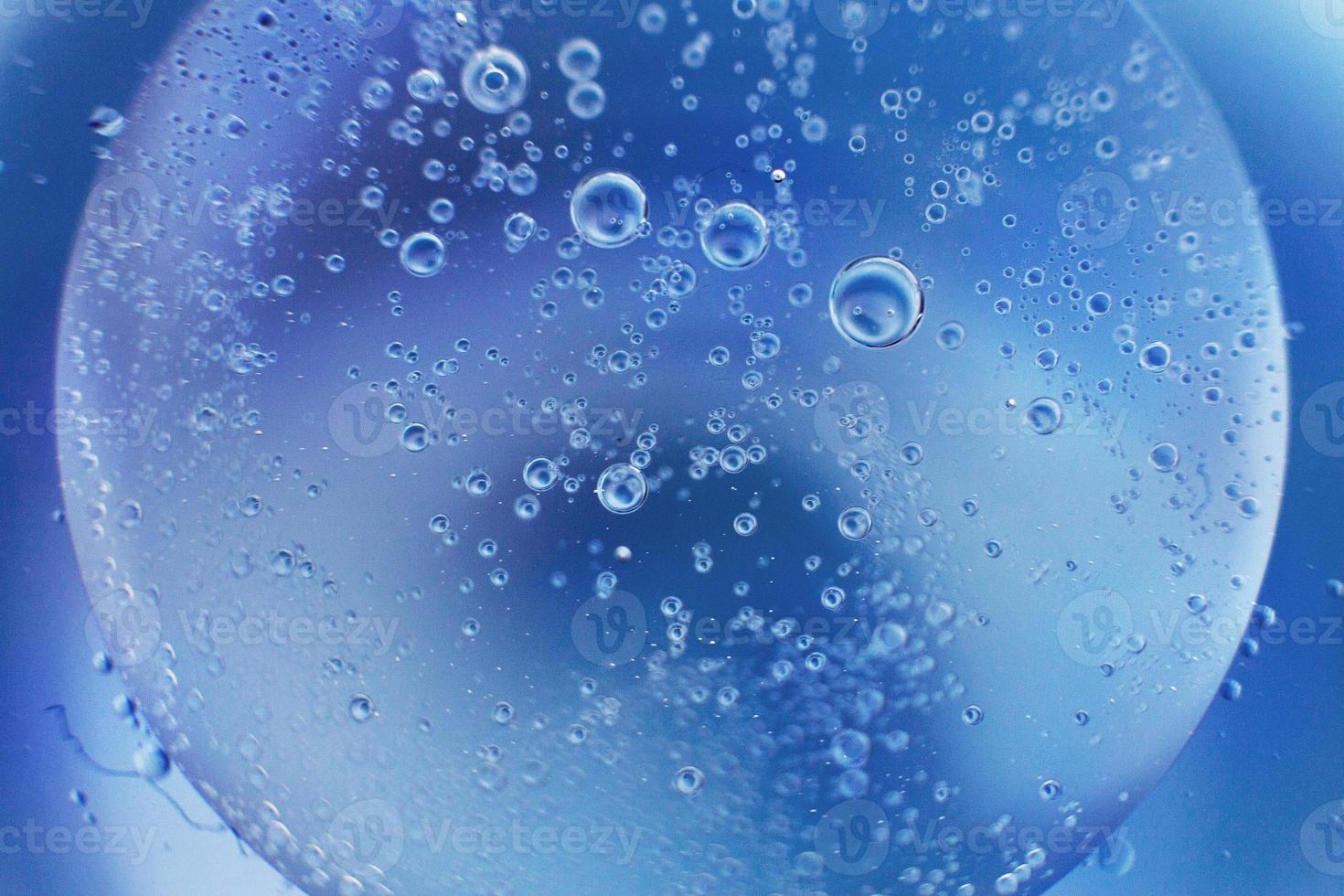 abstrakt ljus blå bakgrund med olja cirklar . bubblor av vatten stänga upp . olja bubblor i de vatten makro. cirkel bubblor bakgrund foto