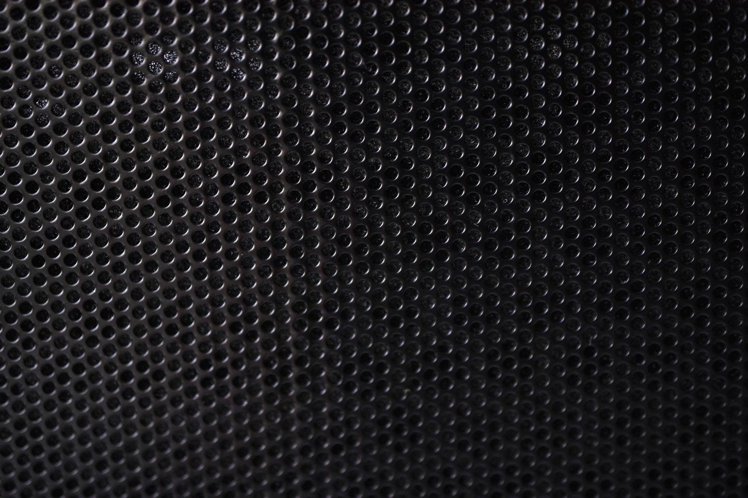 svart bakgrund gjord av järngaller med små runda hål foto