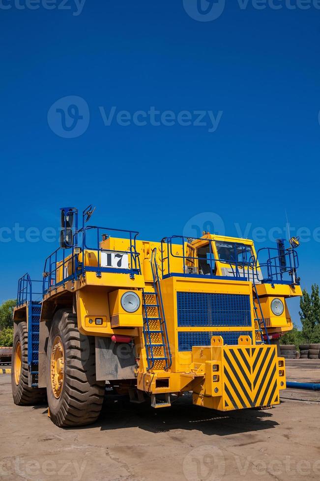 tung gul stenbrott traktor på reparera station på solig molnfri dag foto