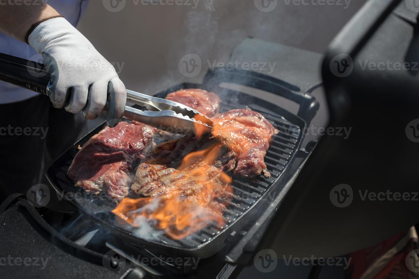 de kockens händer fritera de kött.grillat kött. rostad bit av nötkött under matlagning. foto