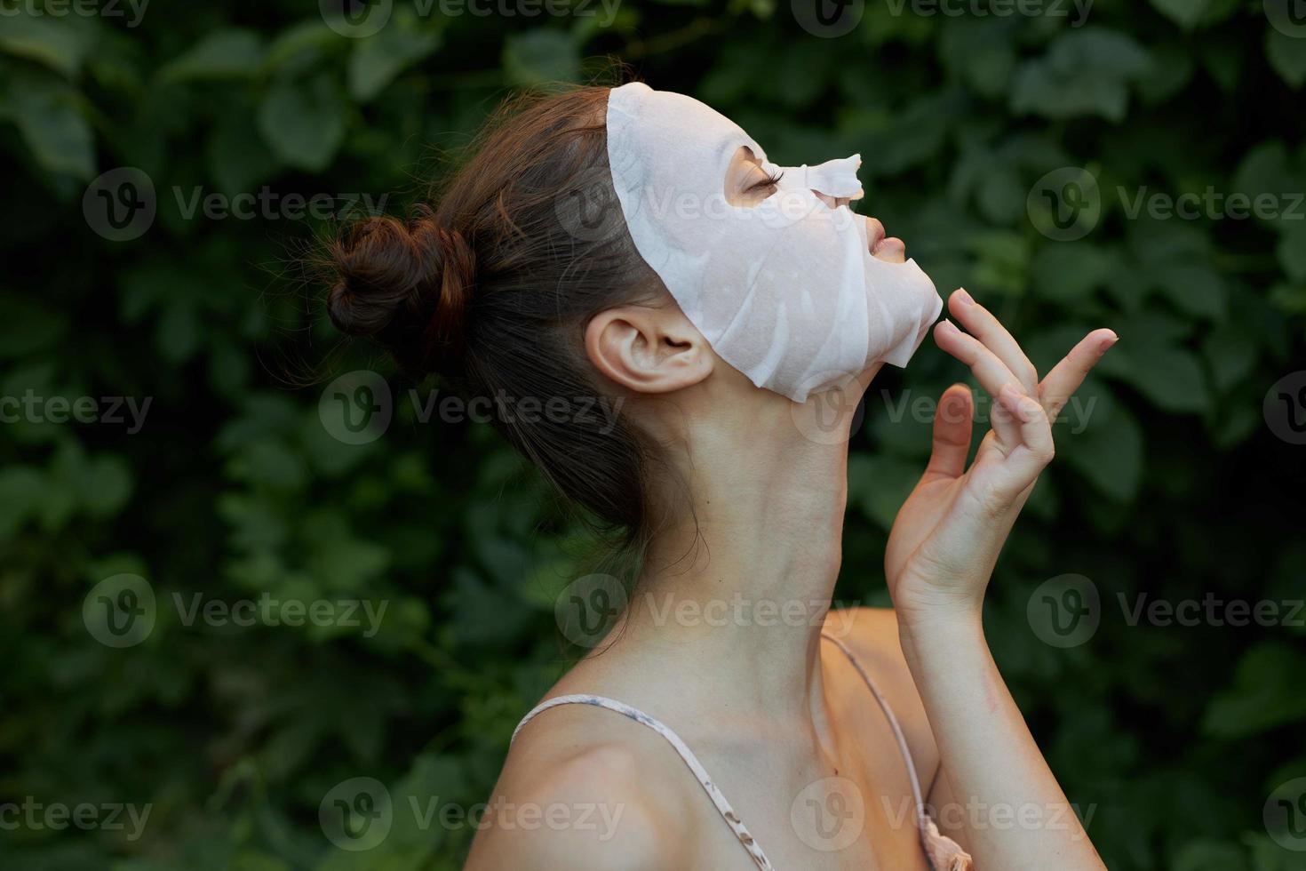 trevlig flicka kosmetisk mask rörande ansikte med hand sida se klar hud foto