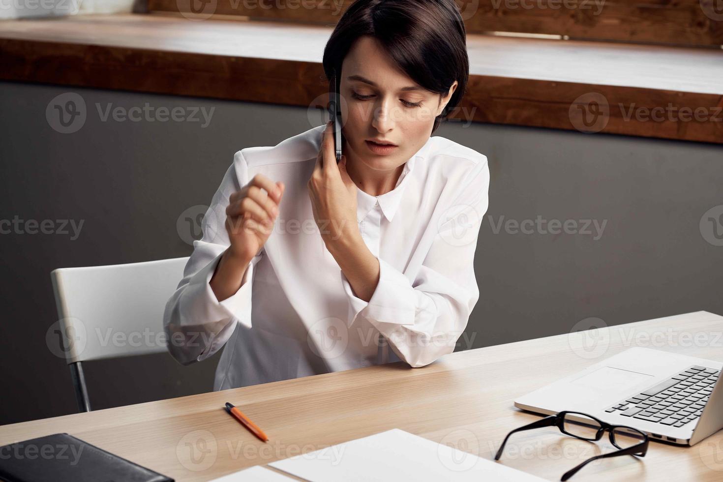 kvinna i kostym i främre av bärbar dator med glasögon självförtroende ljus bakgrund foto
