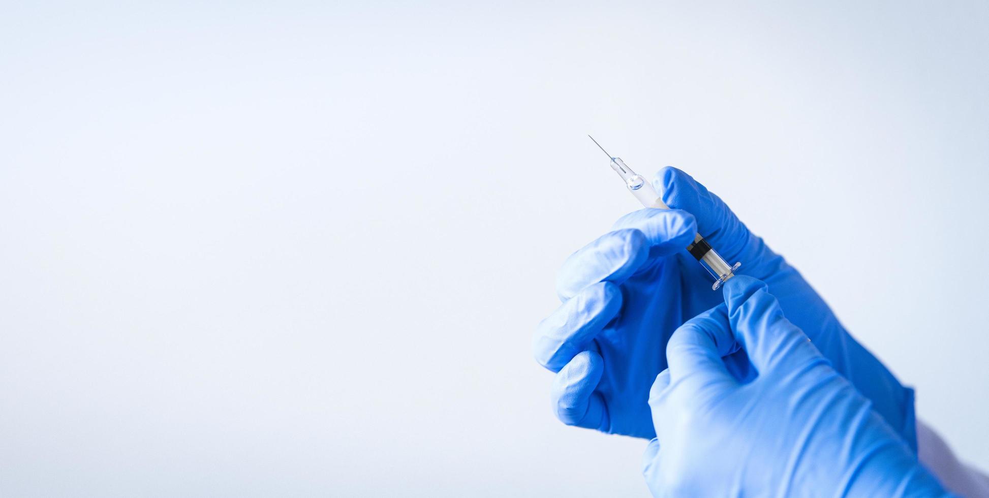 närbild av sjuksköterskahänder som rymmer vaccinet med blå handskar foto