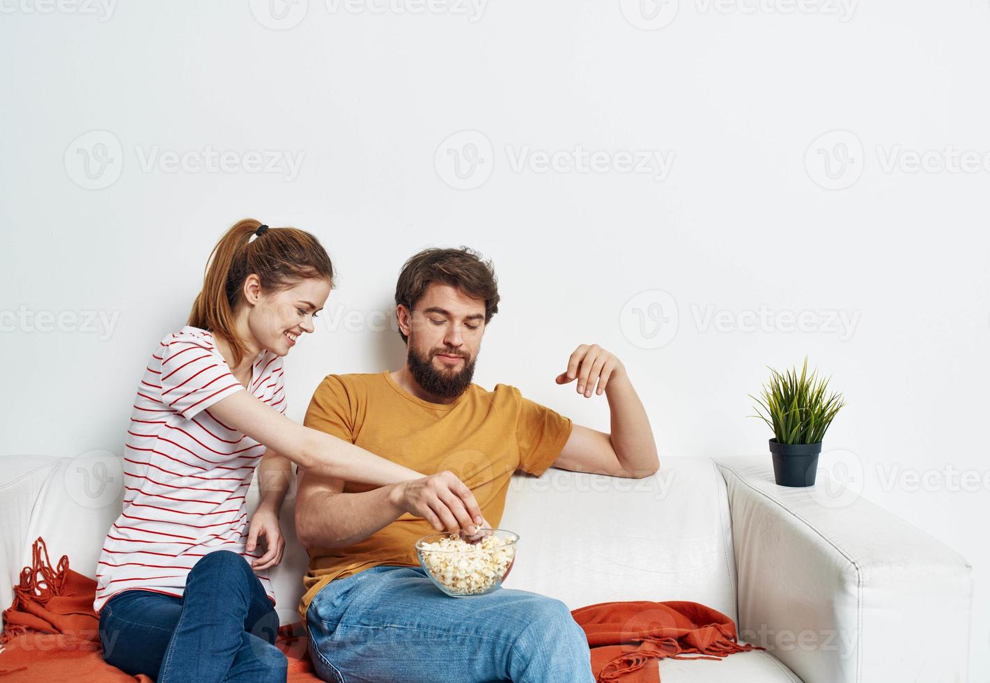 emotionell man och kvinna på de soffa orange pläd blomma i en pott chattar vänner foto