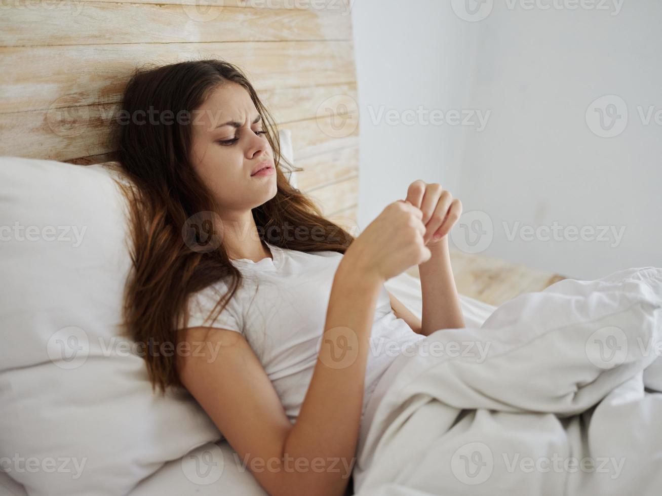 upprörd kvinna liggande i säng med hög feber foto