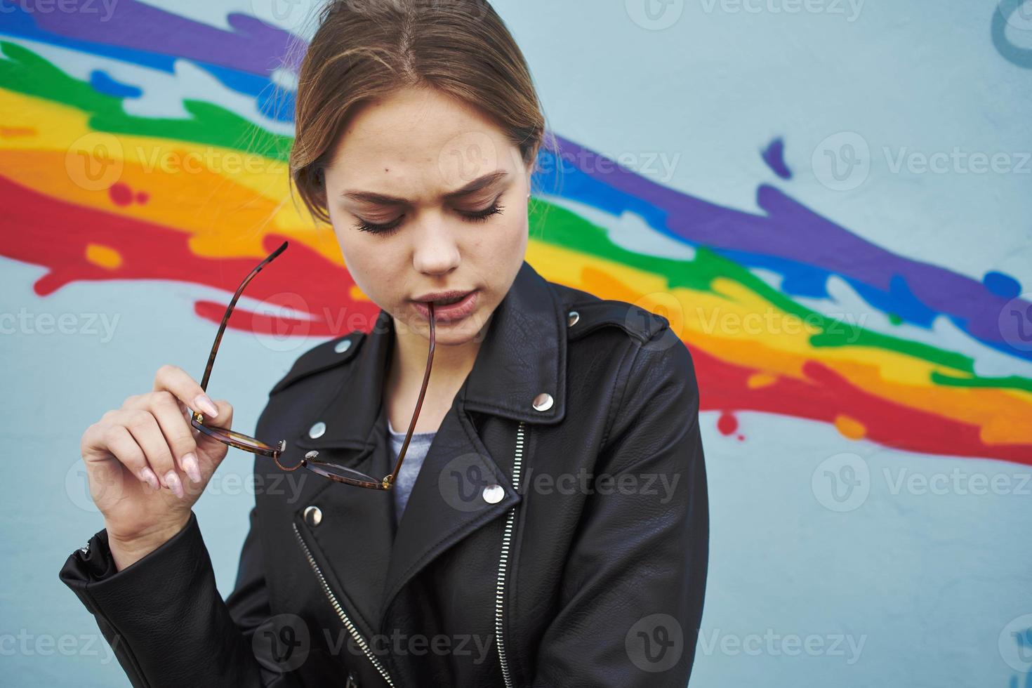 glad kvinna läder jacka roligt känslor glasögon och flerfärgad graffiti foto