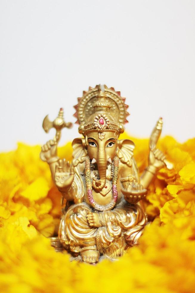 guld ganesha staty Gud är de herre av Framgång Gud av hinduism på ringblomma blommor isolerat på vit bakgrund. foto