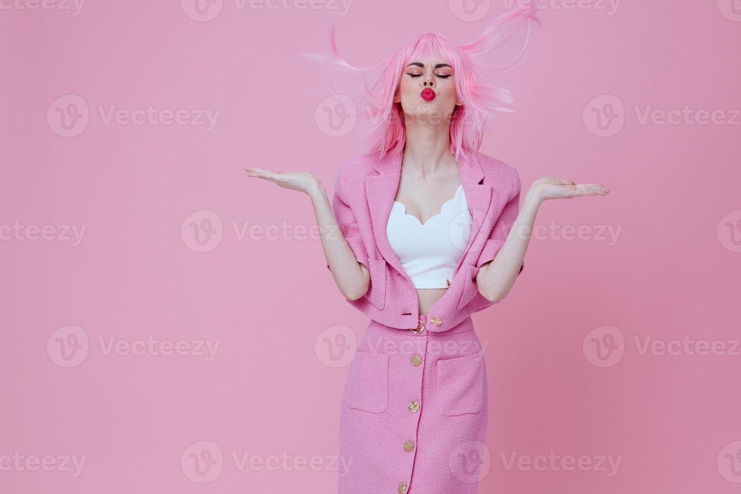 skönhet mode kvinna i en rosa kostym gestikulerar med hans händer känslor roligt rosa bakgrund oförändrad foto