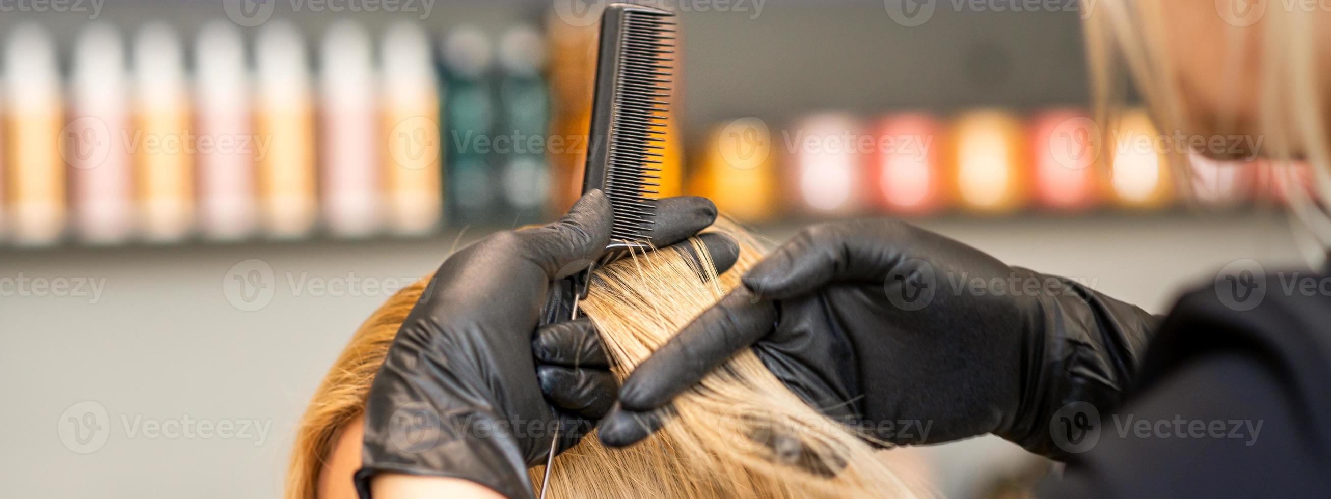 frisör kammande klientens kvinna hår foto