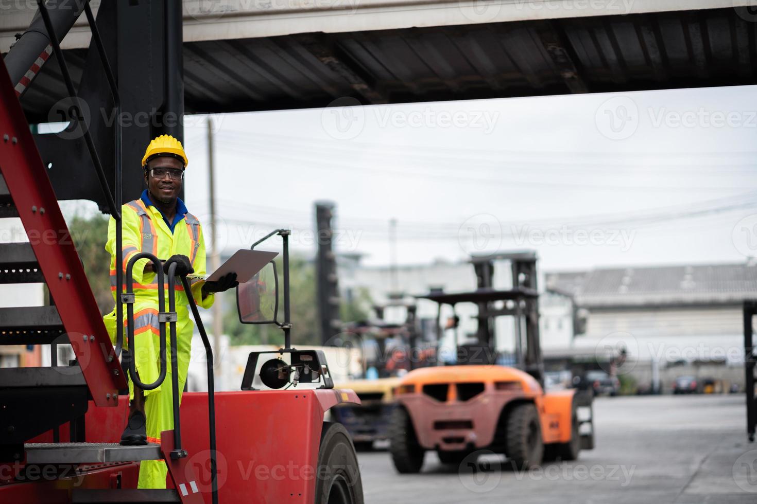 ingenjör man arbetstagare i säkerhet overall enhetlig med gul Hardhat och använda sig av bärbar dator dator kontrollera på frakt behållare fartyg hamn lager.transport import Export logistisk industriell service foto